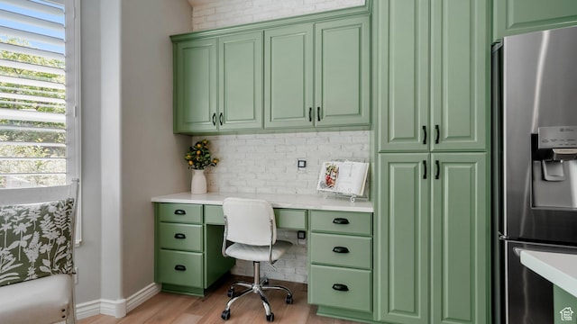 office with built in study area, light wood finished floors, and baseboards