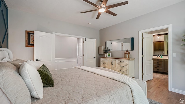 bedroom featuring light wood-style flooring, ensuite bathroom, and ceiling fan