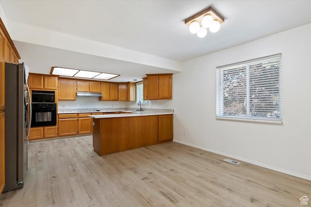 754 W 2100 N, Provo, UT 84604 - kitchen with black appliances, a peninsula, light wood-style flooring, and brown cabinetry