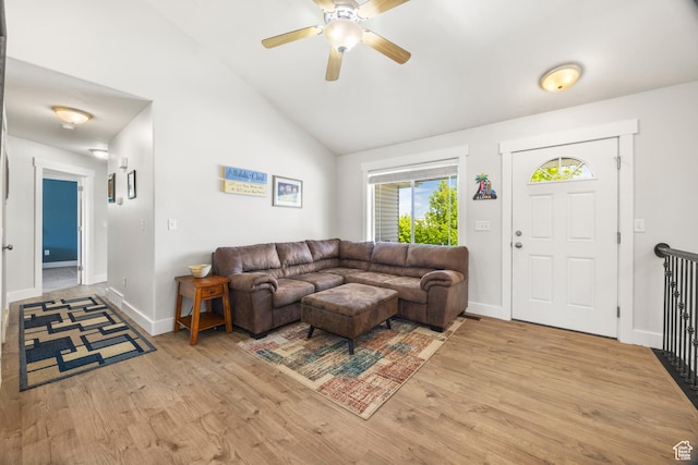 living area with light wood-type flooring, ceiling fan, lofted ceiling, and baseboards