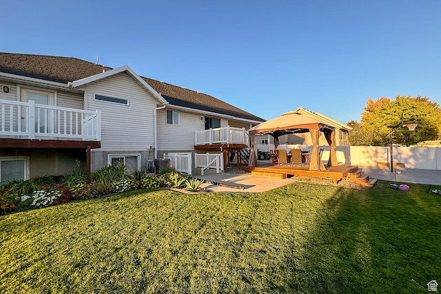 rear view of house with a gazebo, a yard, and a wooden deck