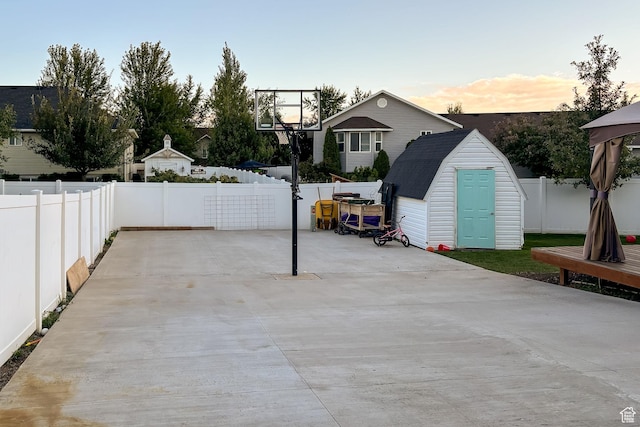 view of patio featuring a storage shed, a fenced backyard, and an outbuilding