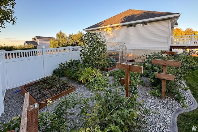 view of yard featuring a garden, an exterior structure, fence, and an outdoor structure