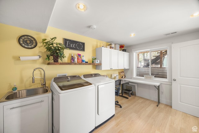 laundry area featuring washing machine and clothes dryer, cabinet space, light wood-type flooring, and recessed lighting