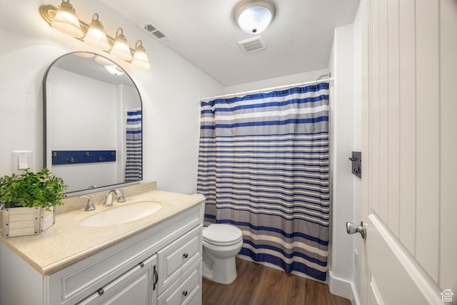 bathroom with toilet, vanity, wood finished floors, and a shower with shower curtain