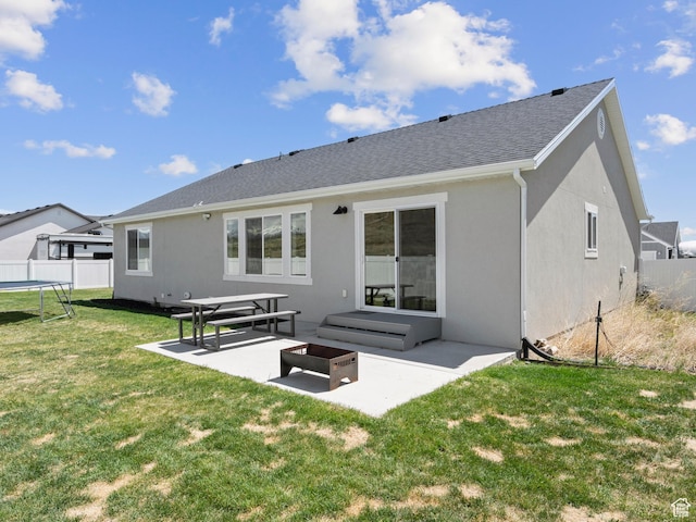 back of property featuring a patio area, a trampoline, stucco siding, and a shingled roof