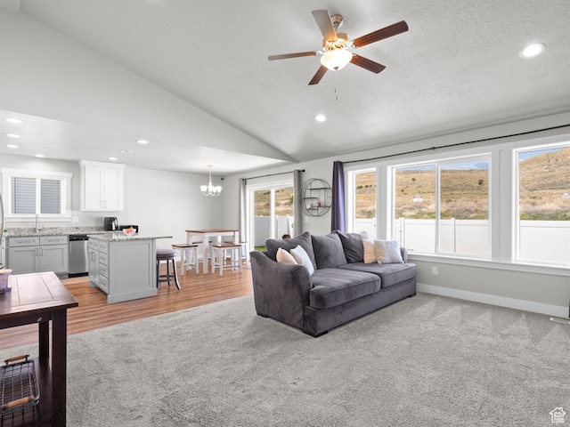 living area with lofted ceiling, recessed lighting, a ceiling fan, a chandelier, and baseboards