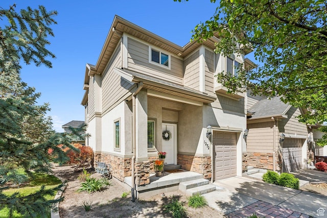 view of front of home featuring stone siding, concrete driveway, stucco siding, and a garage
