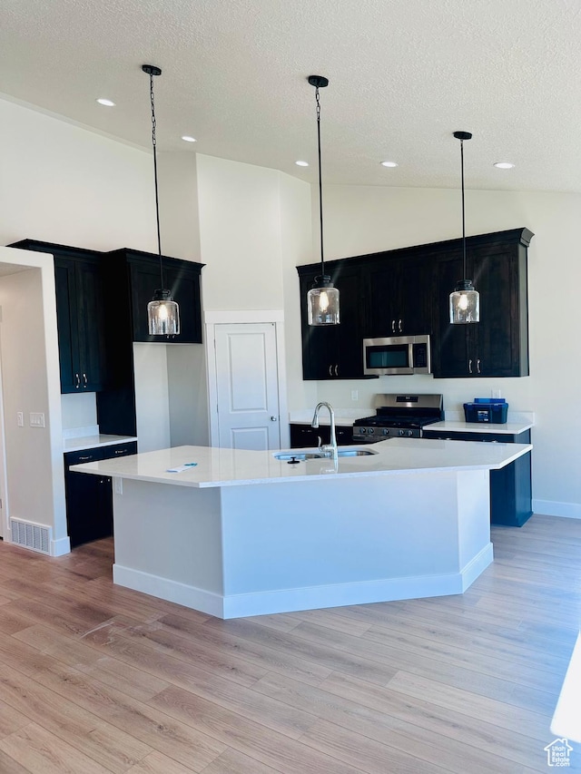 566 W 1860 N, Tooele, UT 84074 - kitchen featuring a sink, appliances with stainless steel finishes, dark cabinetry, a textured ceiling, and light countertops
