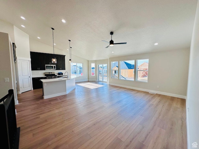 566 W 1860 N, Tooele, UT 84074 - unfurnished living room with a sink, ceiling fan, light wood-style flooring, lofted ceiling, and recessed lighting