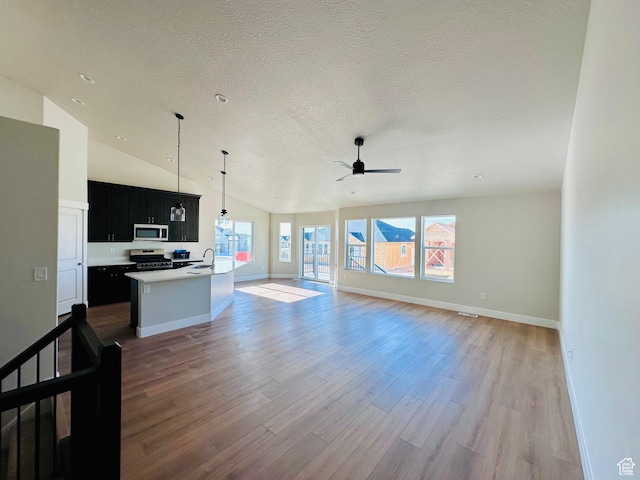 566 W 1860 N, Tooele, UT 84074 - kitchen with appliances with stainless steel finishes, dark cabinetry, open floor plan, wood finished floors, and ceiling fan