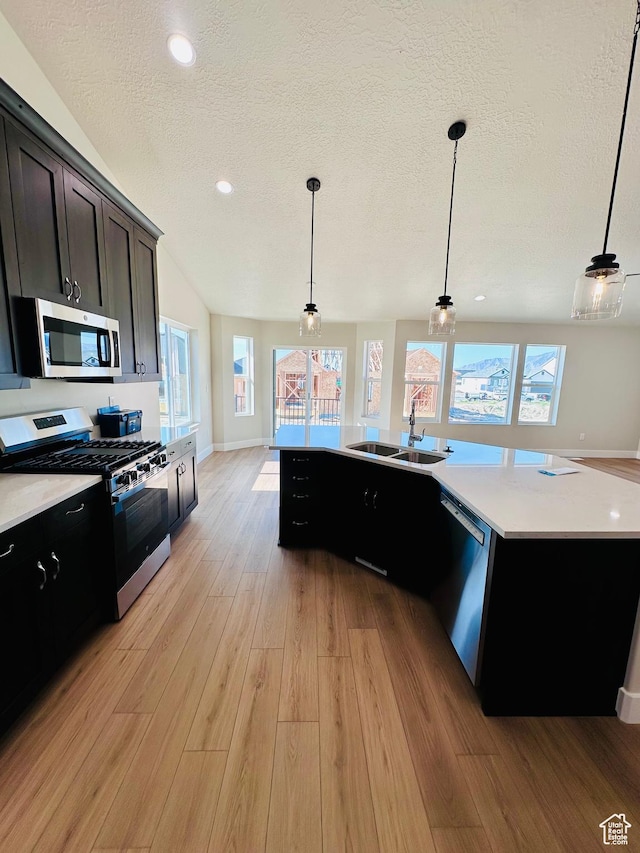 566 W 1860 N, Tooele, UT 84074 - kitchen with stainless steel appliances, a sink, a textured ceiling, light wood-style floors, and light countertops