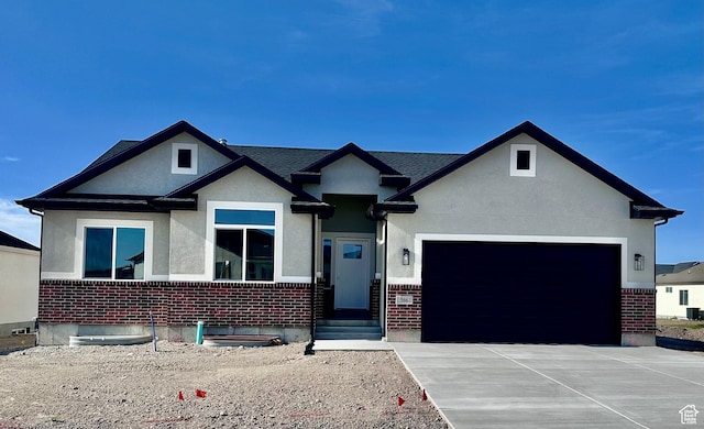 566 W 1860 N, Tooele, UT 84074 - view of front of home featuring a garage, brick siding, stucco siding, and concrete driveway