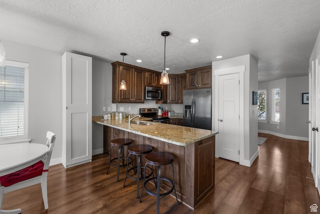 2051 W 1080 N, Provo, UT 84604 - kitchen with appliances with stainless steel finishes, baseboards, a sink, a peninsula, and dark wood finished floors