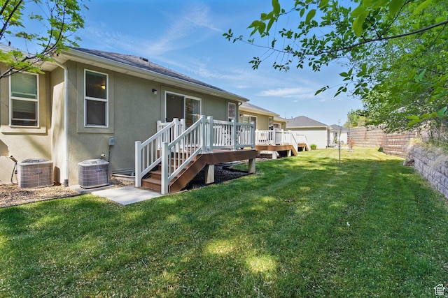 back of house featuring stucco siding, a wooden deck, central air condition unit, and roof with shingles
