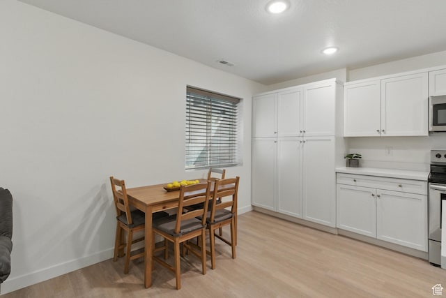 dining room featuring light wood finished floors, baseboards, and recessed lighting