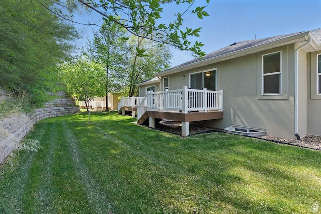 view of grassy yard with a deck