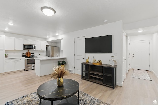 living area featuring light wood-type flooring, recessed lighting, and baseboards