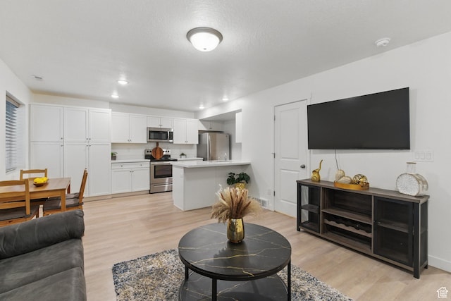 living room with light wood finished floors and recessed lighting