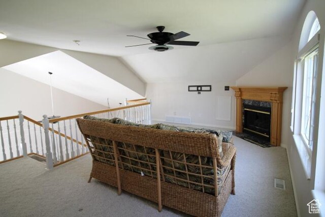 living area featuring ceiling fan, carpet flooring, lofted ceiling, and a premium fireplace