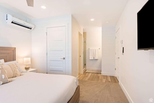 bedroom with a wall mounted AC, light colored carpet, recessed lighting, and baseboards