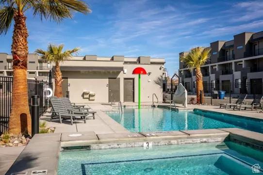 community pool with fence and a patio