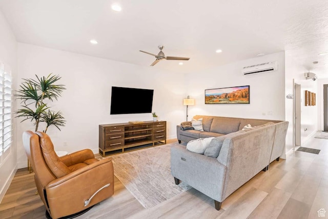 living room featuring an AC wall unit, light wood finished floors, baseboards, ceiling fan, and recessed lighting