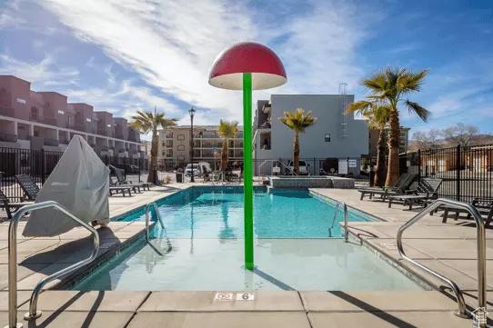 community pool featuring fence and a patio area
