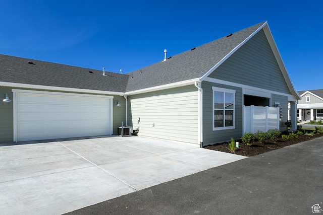 3786 S 4250 W Unit 427, West Haven, UT 84401 - view of home's exterior with driveway, a shingled roof, a garage, and cooling unit