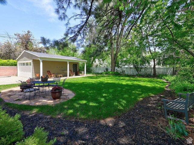 view of yard featuring a garage and a patio area
