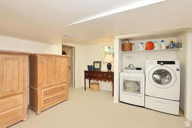 laundry area featuring separate washer and dryer and light colored carpet
