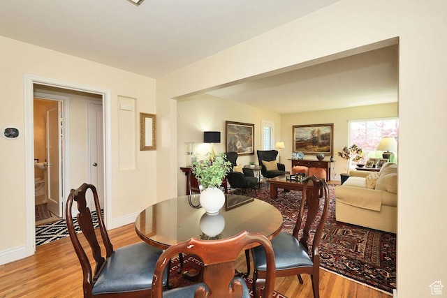 dining space featuring light wood-type flooring and baseboards