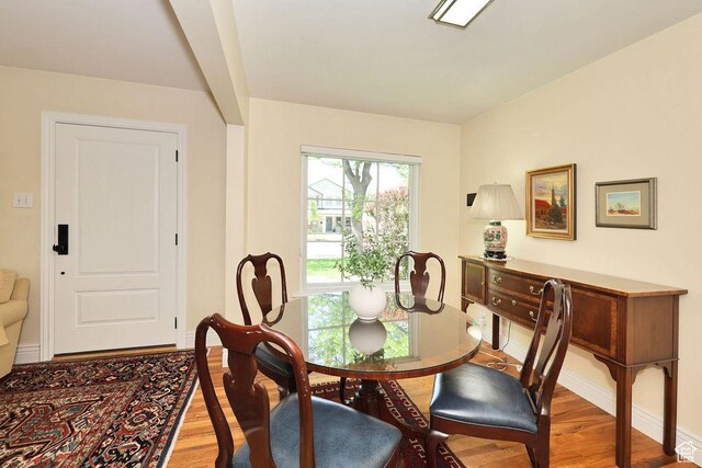 dining space with light wood-style flooring and baseboards