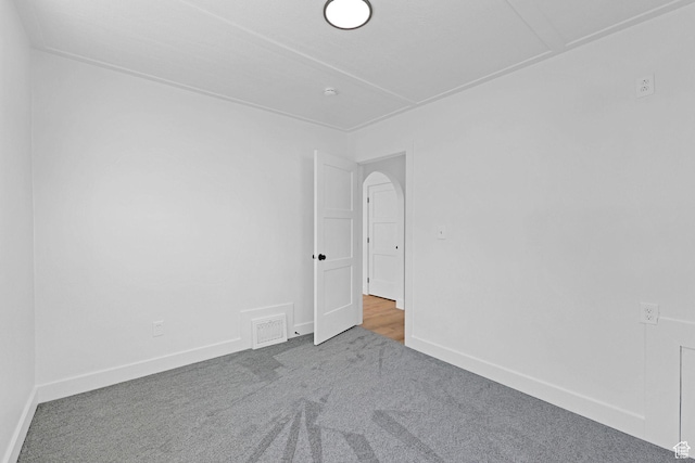 carpeted spare room featuring baseboards