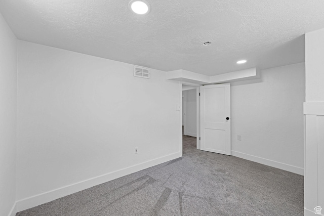spare room featuring a textured ceiling, carpet, baseboards, and recessed lighting