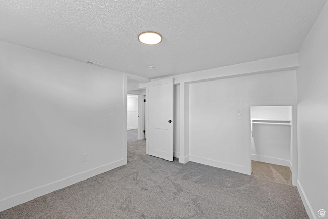 basement featuring carpet, a textured ceiling, and baseboards