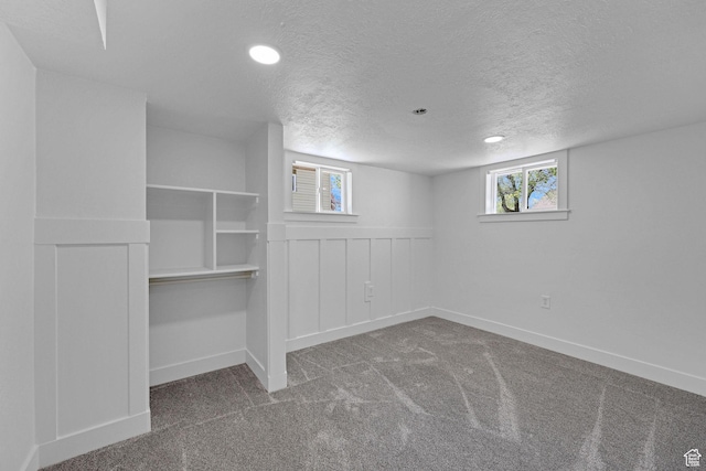 basement with carpet floors, a textured ceiling, baseboards, and recessed lighting