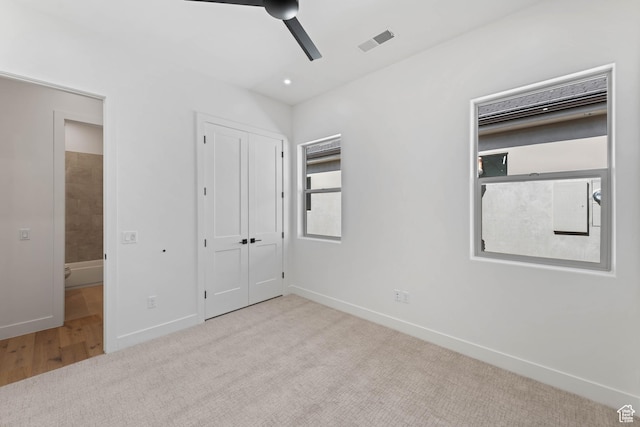 unfurnished bedroom featuring carpet, baseboards, a ceiling fan, and a closet