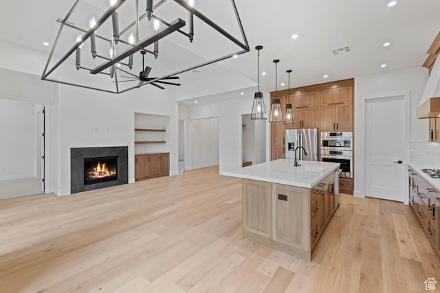kitchen featuring appliances with stainless steel finishes, light wood-style flooring, light countertops, recessed lighting, and tasteful backsplash