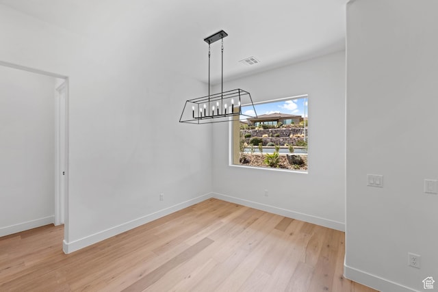 unfurnished dining area featuring light wood-style flooring and baseboards