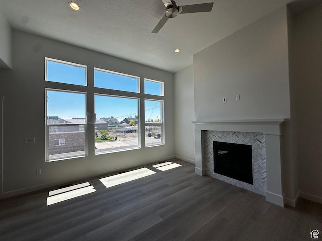 unfurnished living room with baseboards, wood finished floors, ceiling fan, recessed lighting, and a fireplace