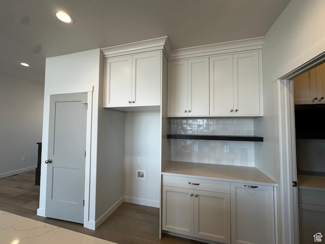 kitchen featuring decorative backsplash, wood finished floors, baseboards, and recessed lighting