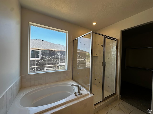 full bathroom with a shower stall, a bath, a textured ceiling, marble look tiles, and recessed lighting