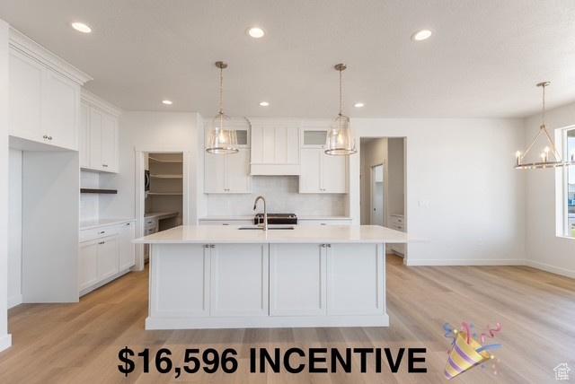 3573 W 725 S Unit 106, West Weber, UT 84401 - kitchen with white cabinets, light countertops, light wood-style floors, recessed lighting, and a kitchen island with sink