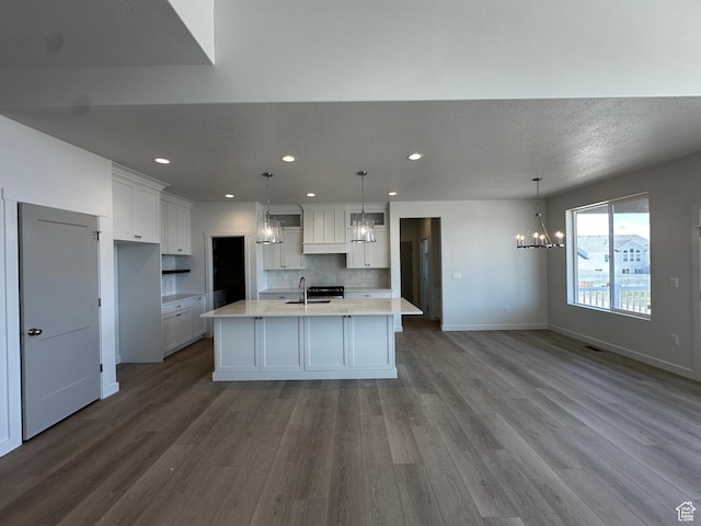 kitchen with a chandelier, a sink, white cabinetry, dark wood-style flooring, and recessed lighting