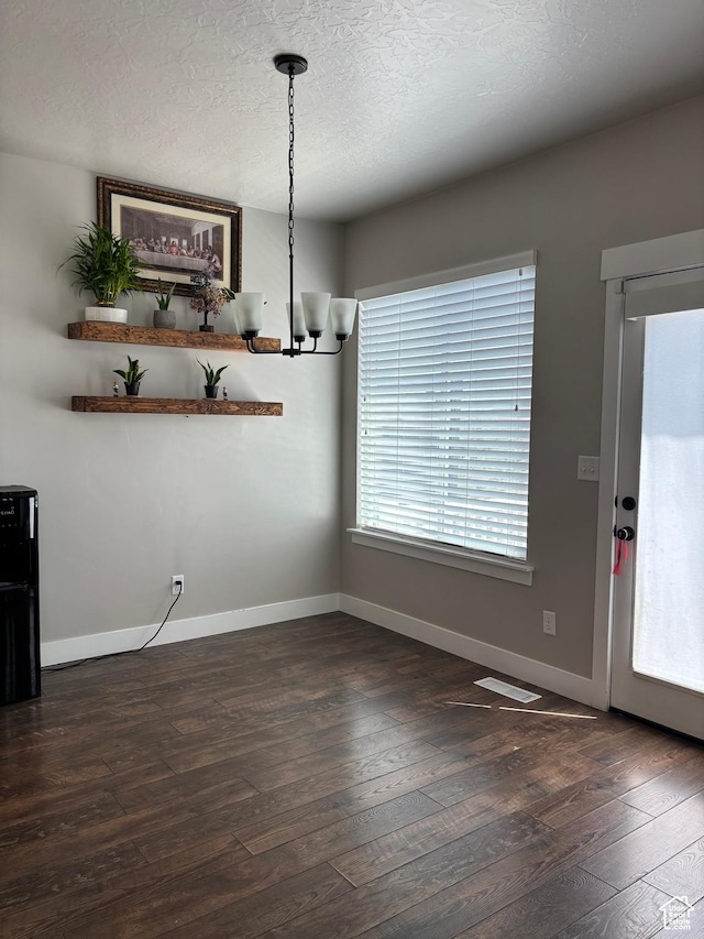 4317 W Quiet Shade Dr, Herriman, UT 84096 - unfurnished dining area with dark wood-style flooring, baseboards, a chandelier, and a textured ceiling