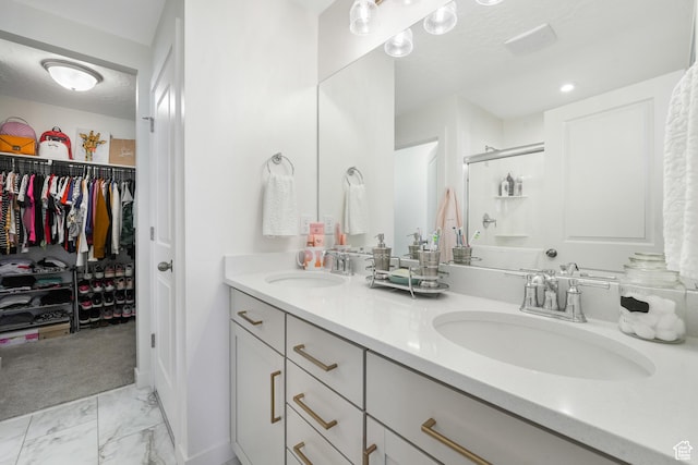 bathroom with a stall shower, marble look tile flooring, double vanity, and a spacious closet