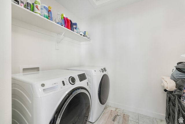 laundry room featuring independent washer and dryer, light marble finish flooring, and baseboards
