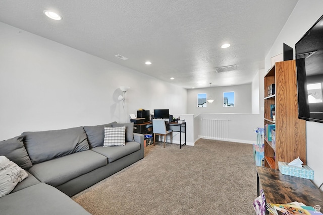 living area with a desk, a textured ceiling, recessed lighting, dark colored carpet, and baseboards