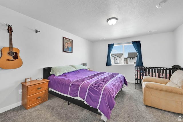 bedroom with carpet floors, baseboards, and a textured ceiling